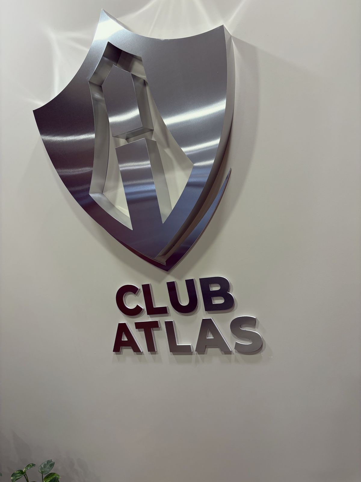 Acercamiento al escudo de aluminio canteado y las letras Club Atlas